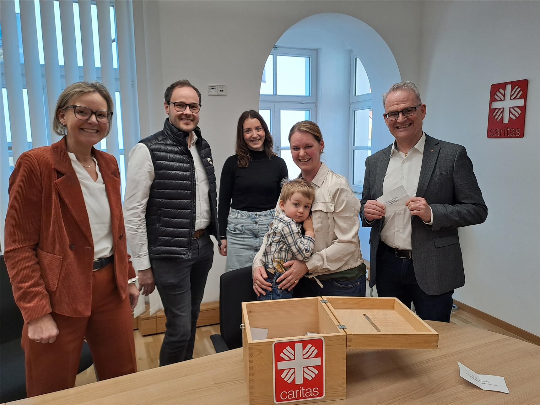 Für fünf Einrichtungen der Caritas hatte der zweijährige Dominik mit seiner Mama Rosa Rosenberger ein glückliches Händchen. Die Caritas-Vorstände Andrea Anderlik und Stefan Seiderer (re.) sowie Patrik