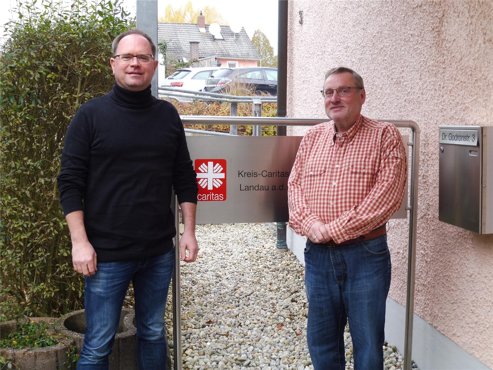 zwei Herren vor dem Dienstgebäude des Kreiscaritasverbandes Landau