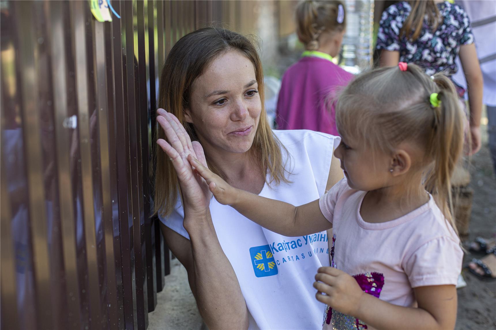 eine Frau tröstet ein Kind in der Ukraine