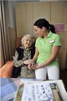 Eine Pflegekraft bei einer alten Dame im Seniorenheim