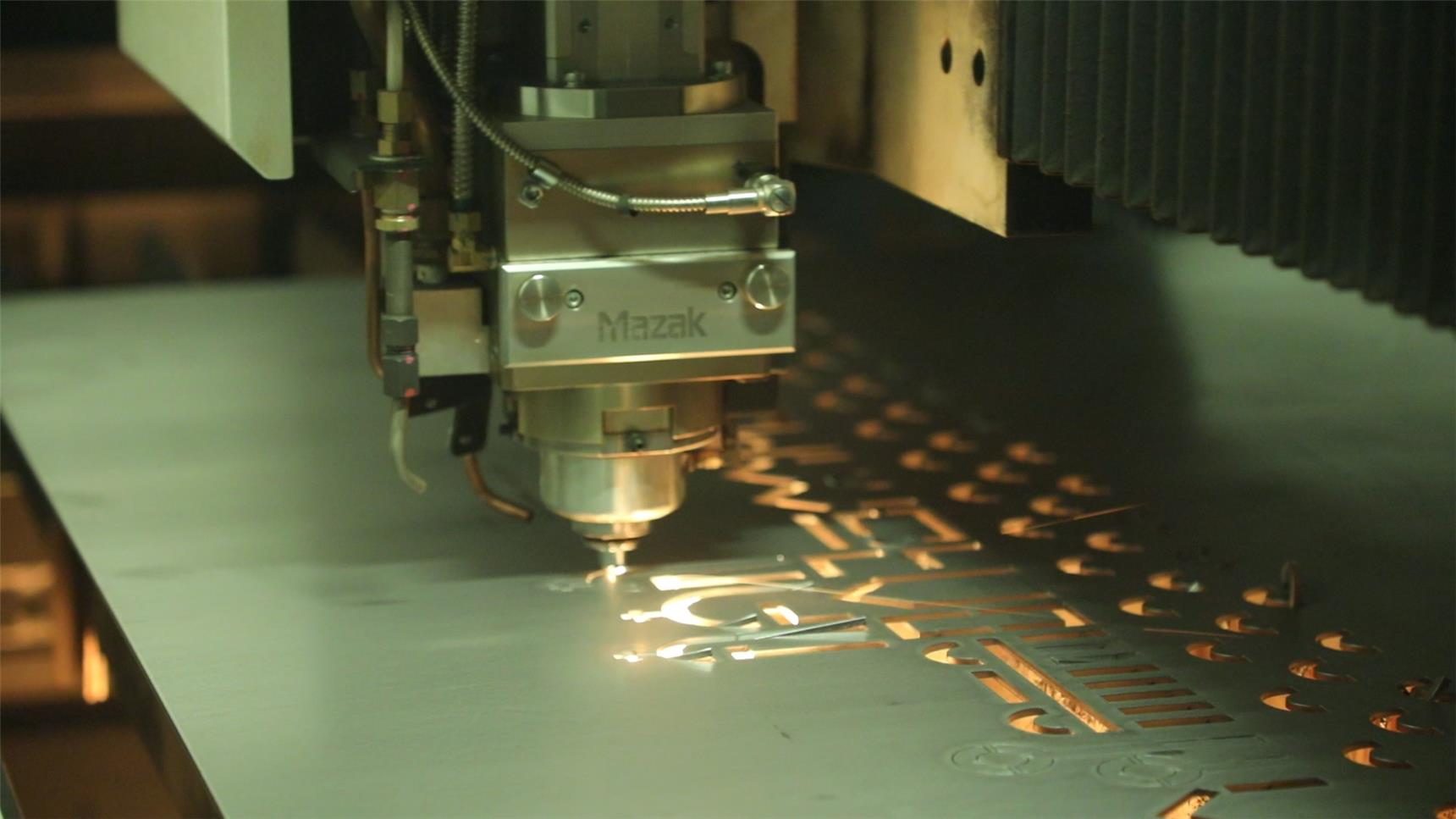 Ein Laser stanzt den Text "Wer glaubt ist nie allein" in den Feuerkorb