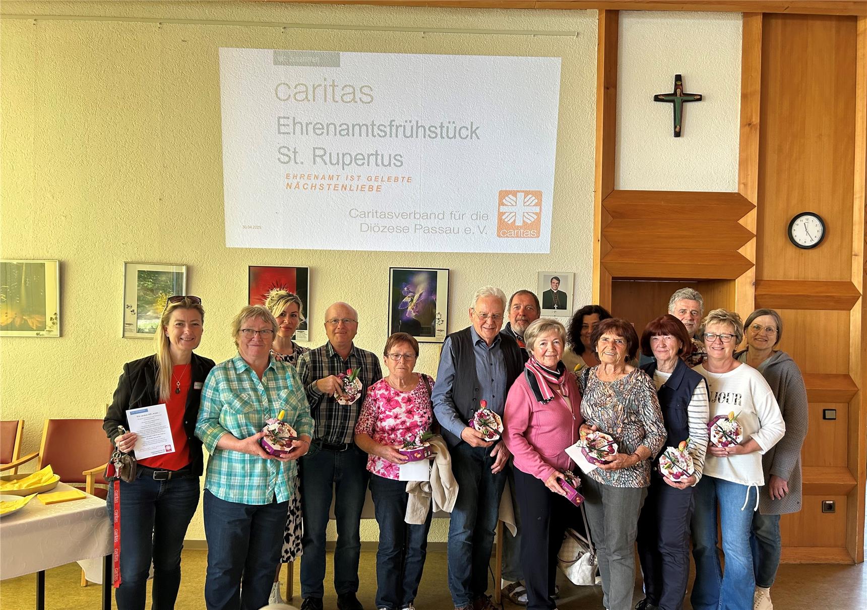 Mehrere Personen stehen als Gruppe zusammen und lachen in die Kamera.