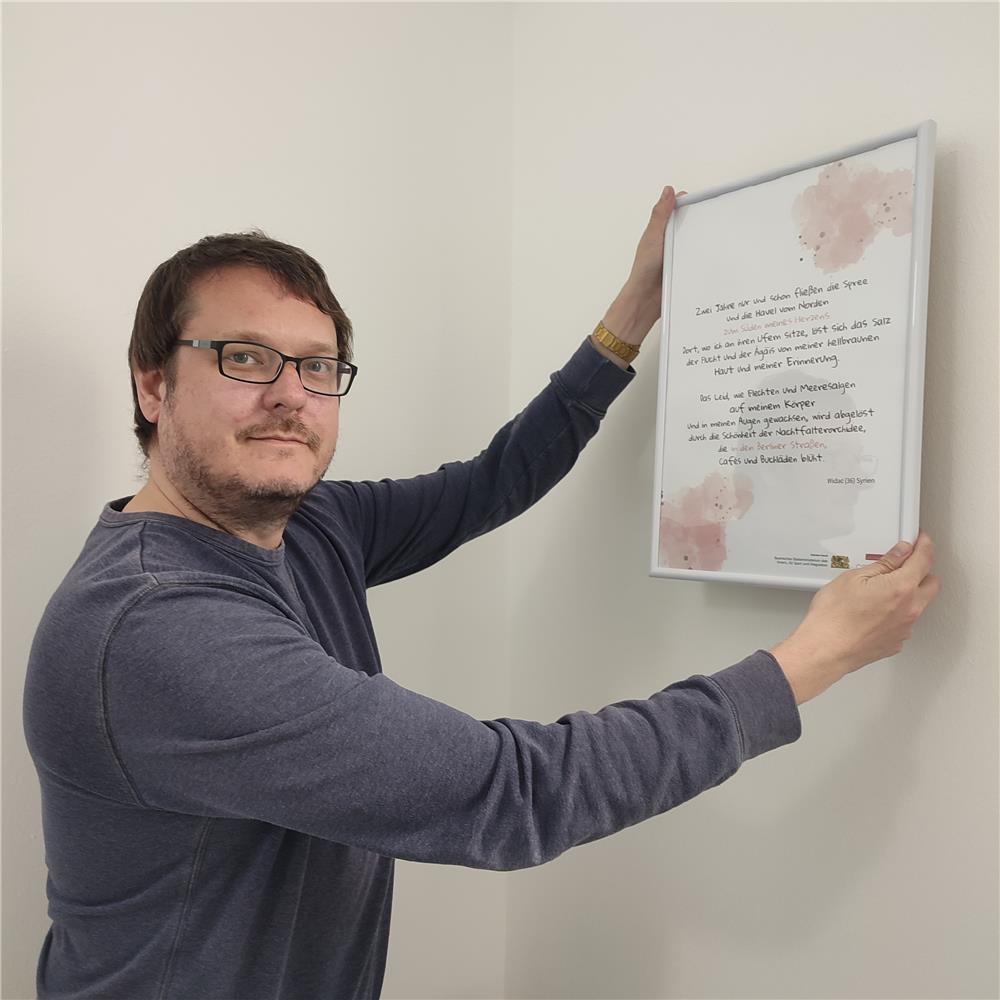 ein Herr zeigt ein Gedicht eines Geflüchteten