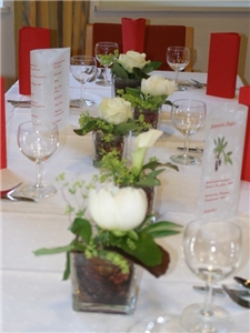 festlich gedeckter Tisch mit Blumendekoration, Weingl�sen, Men�karten und roten Servietten
