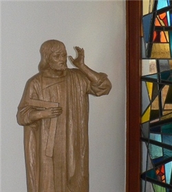 Figur des Heiligen Josef vor buntem Glasfenster