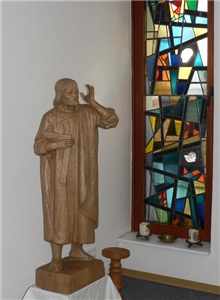 Statue des Heiligen Josef vor buntem Glasfenster in der Kapelle des Hauses
