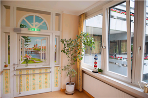 von Illusionsmalern gestaltete Tür, die aussieht wie ein Fenster, von dem aus man über Lübecks Altstadt blicken kann