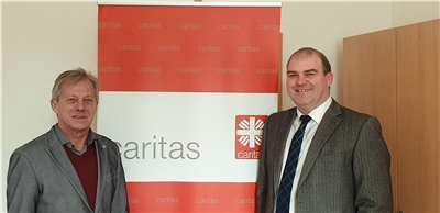 zwei Herren mit Caritas Logo
