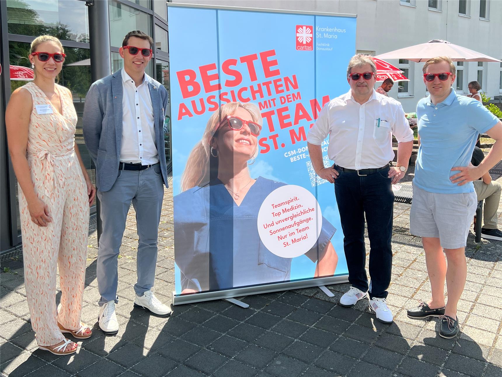 Vier Personen vor einem RollUp 