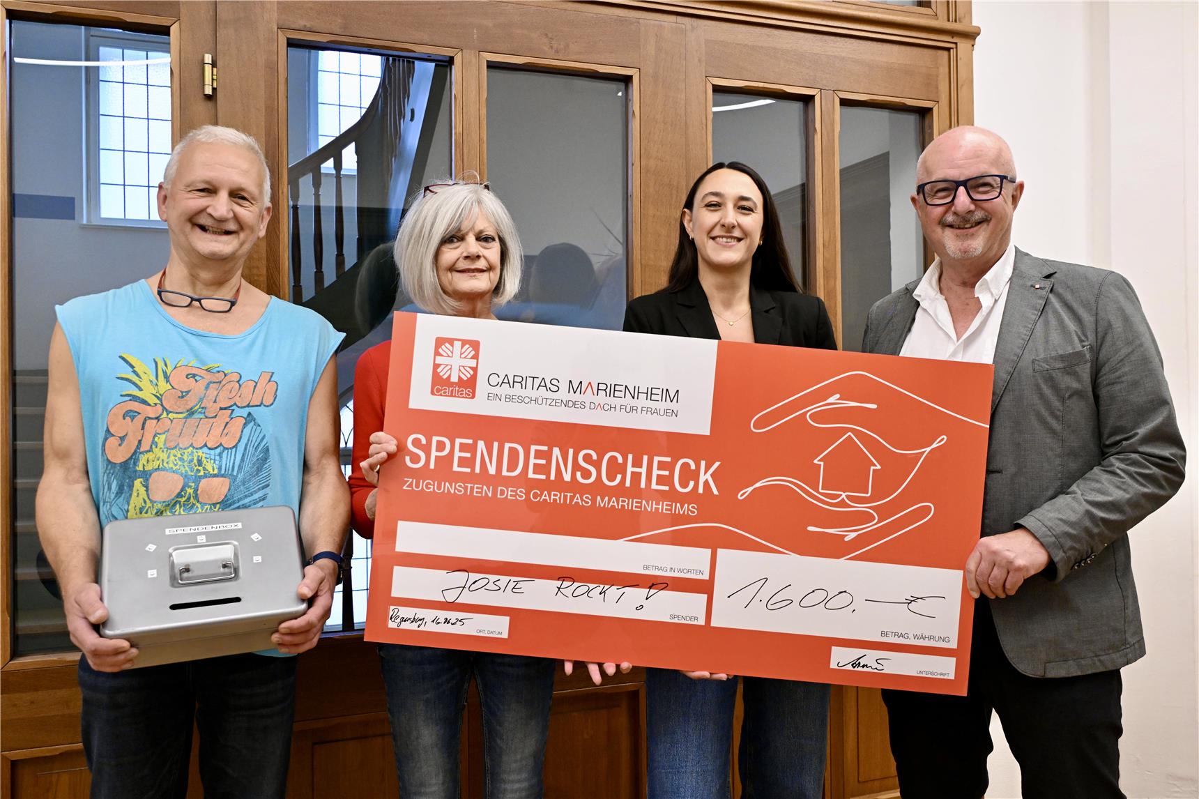 Vier Personen halten einen überdimensional großen Spendenscheck in den Händen. 