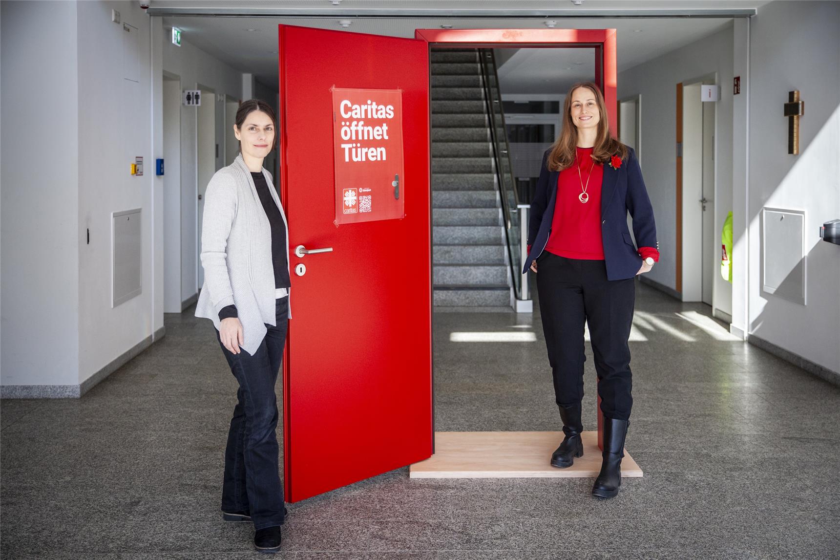 Zwei Frauen im Porträt vor einer roten Tür