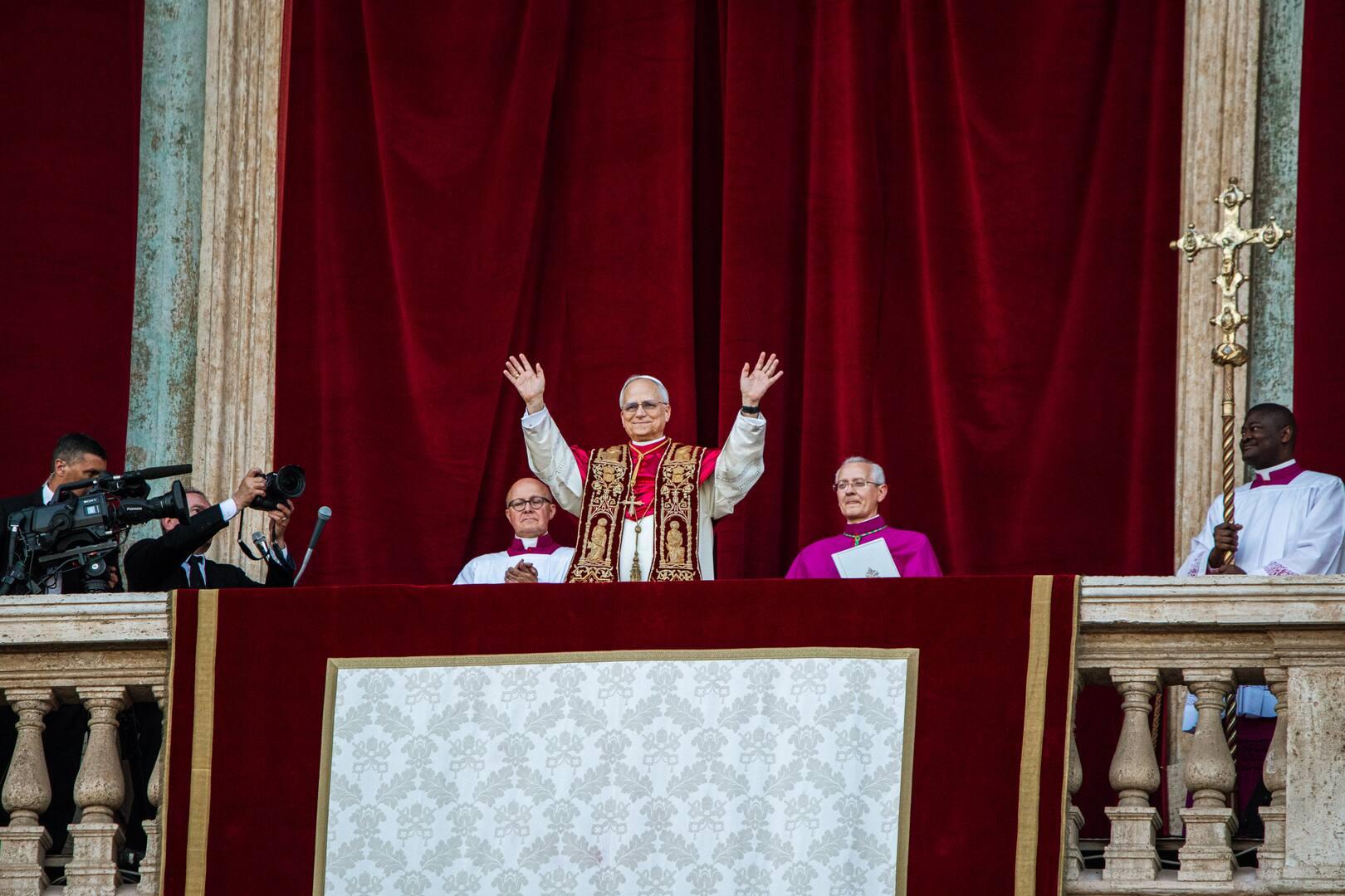 Papst Leo XIV. nach seiner Bekanntgabe auf der Loggia des Petersdoms. Er streckt die Arme nach oben mit geöffneten Händen als Gruß