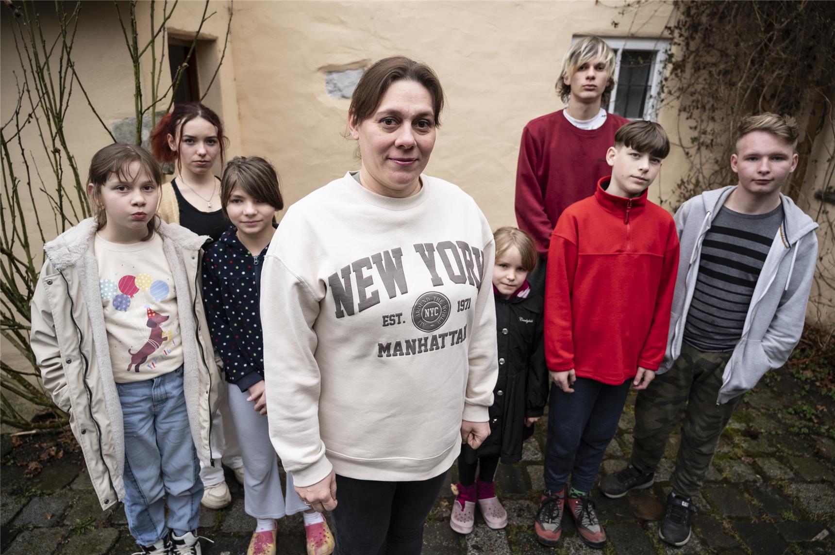 Eine Frau und Kinder vor einem Haus