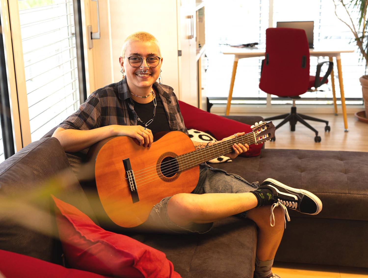 Person mit Gitarre in einem Büro