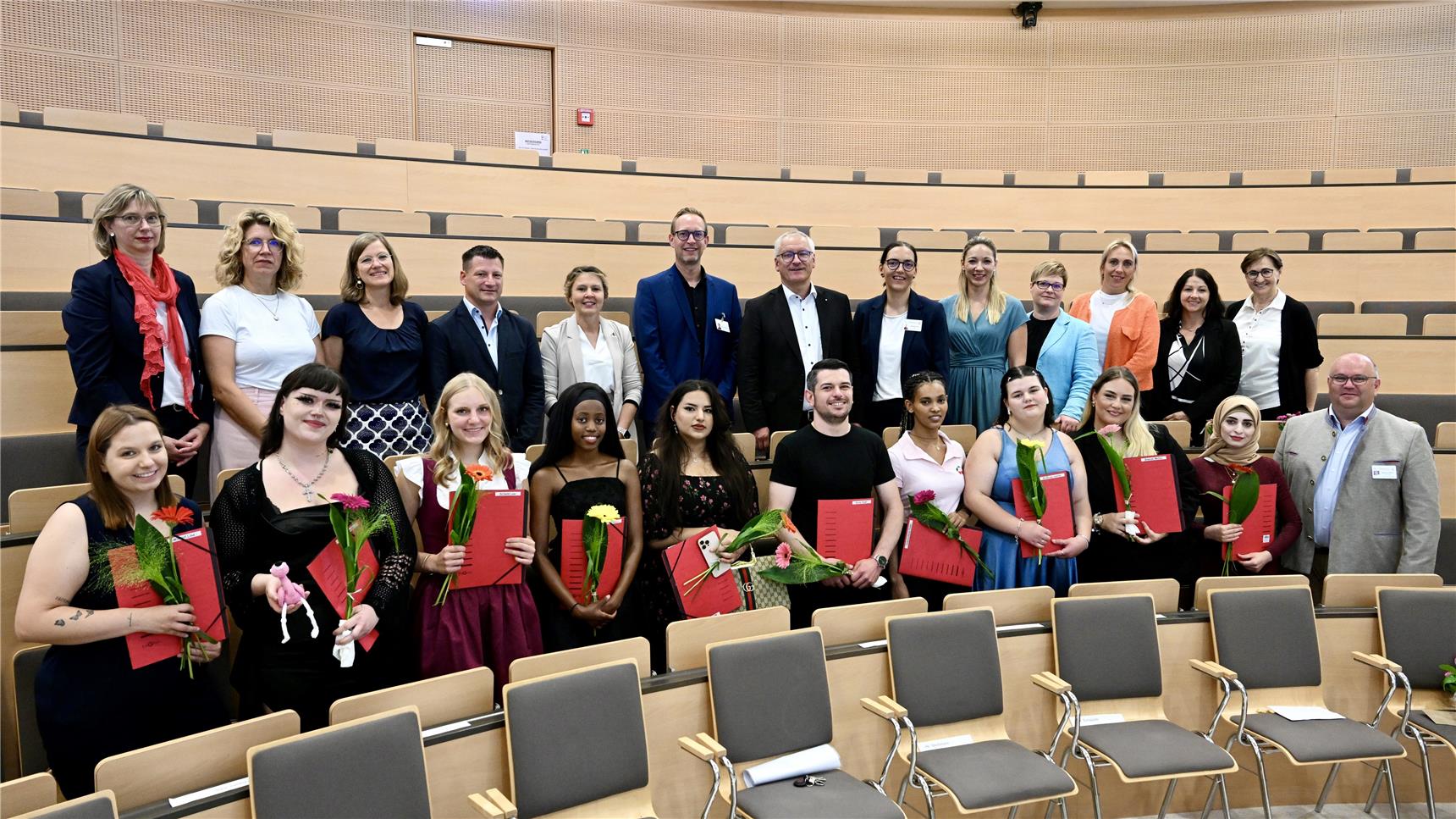 Gruppenbild festlich gekleideter Menschen, darunter die Absolventen