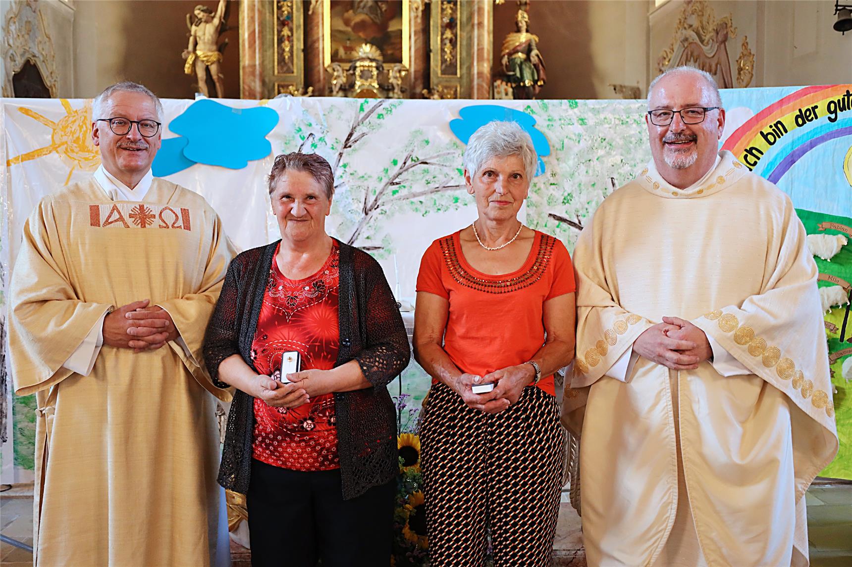 In der Kirche stehen Sammlerinnen in der Mitte umrahmt von Direktor und Pfarrer mit Auszeichnung.
