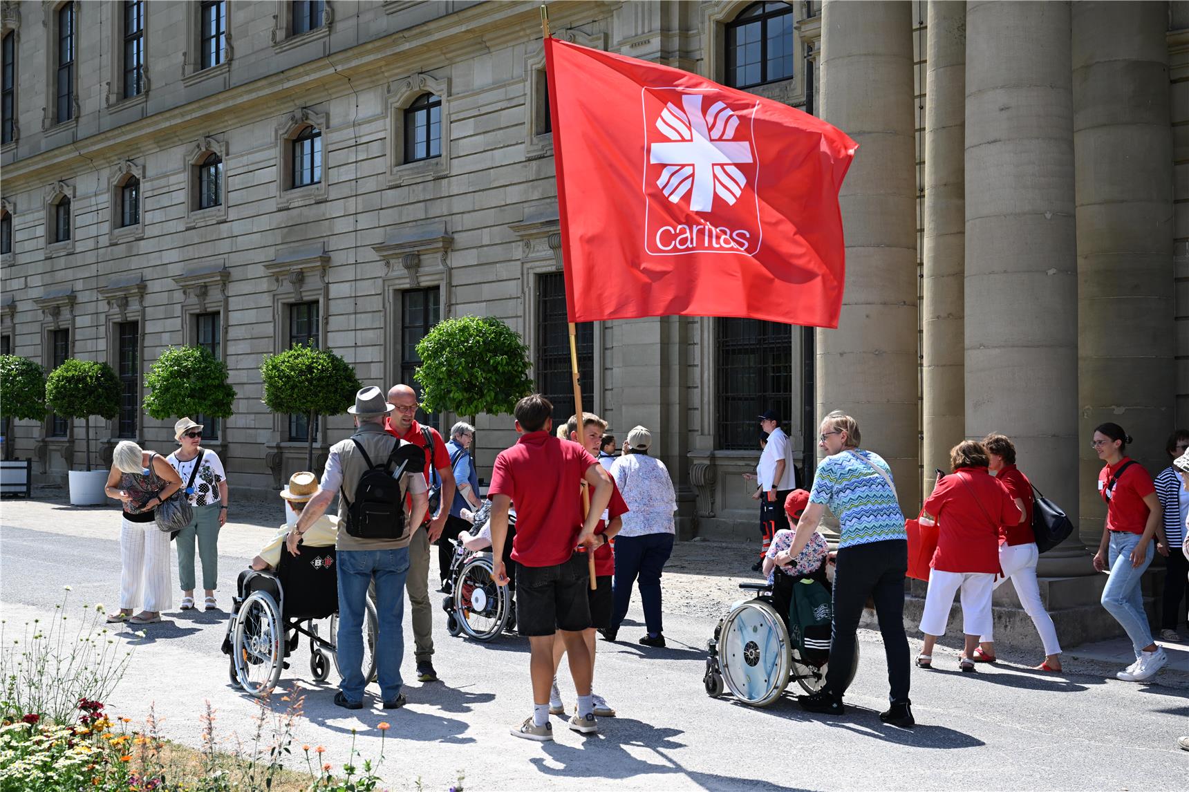 Menschen mit Caritasfahne vor der Würzburger Residenz