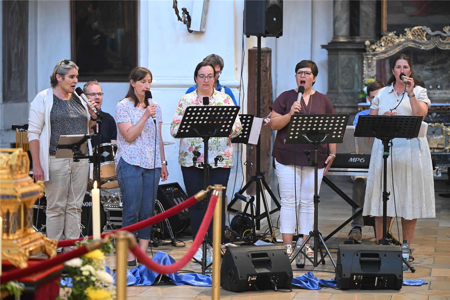 Man sieht die Musigruppe in der Kirche singen.