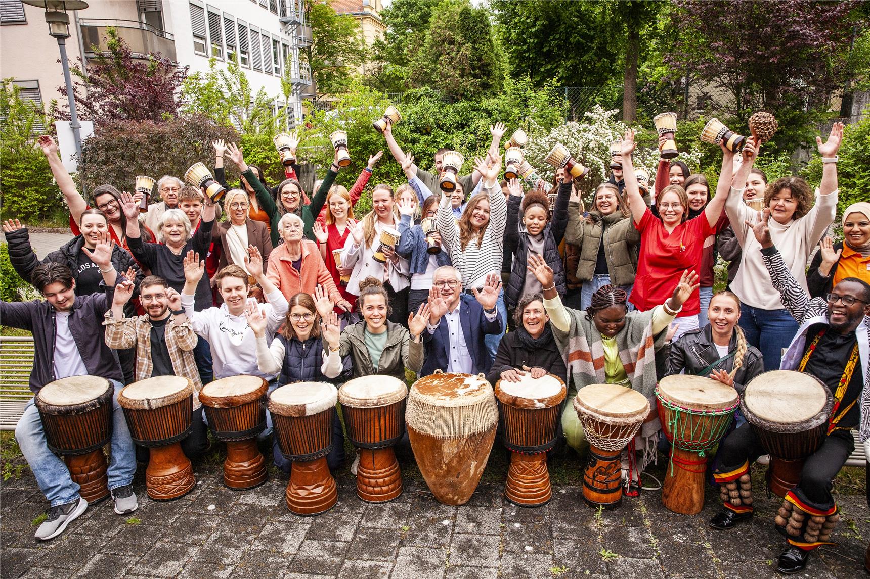 Rund 50 Menschen mit Trommeln und jubelnd