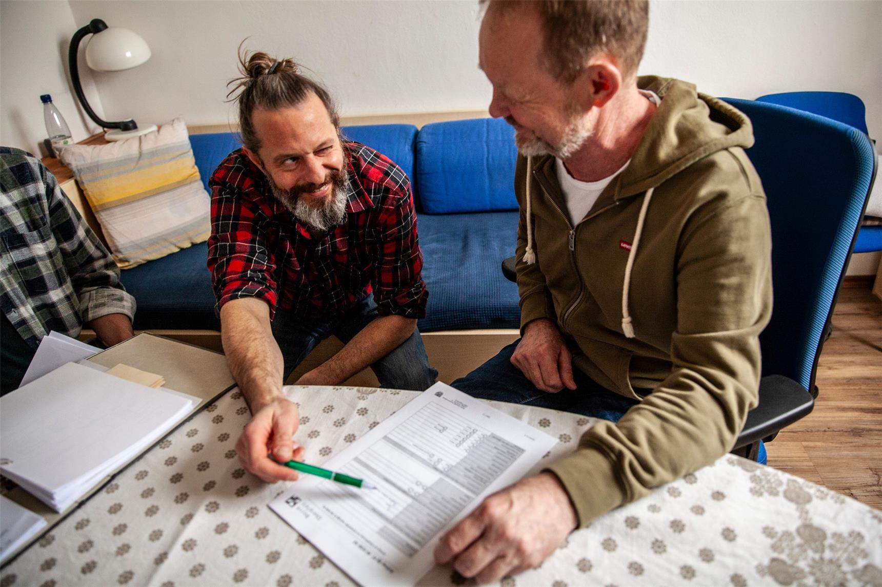 zwei männer sitzen an einem holztisch