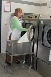 Eine Frau leert die Waschmaschine aus