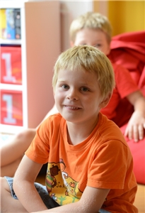 Caritasausschuss Kindertagesstätte Eine Junge grinst in die Kamera.
