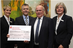 2.500 EURO für Menschen in Not Unser Bild zeigt den Vorstandsvorsitzenden der Sparkasse Saarbrücken, Hans Werner Sander, mit Sandra Birster und Beate Zinke vom Organisationsteam der Sparkasse bei der Scheckübergabe an Caritasdirekt