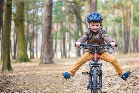Bewegung ist ein Segen für Kinder. Junge fährt Fahrrad durch den Wald
