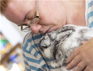 Eine Frau kuschelt mit einem Kaninchen