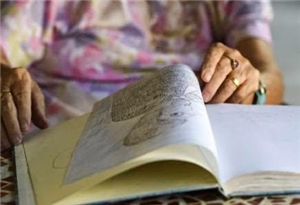 Offenes Buch mit Händen einer alten Frau