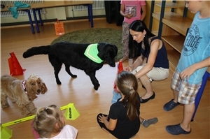 Trainerin Jutta Birk und die Kinder der Freiwillligen Ganztagsschule während einer Übung mit den Hunden