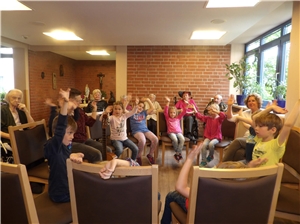 Kindergartenkinder sitzen im Kreis und singen gemeinsam mit den Bweohnern