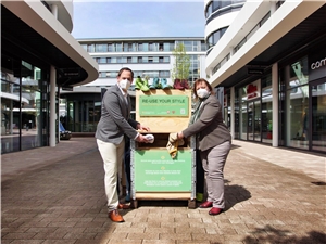 Dorothea Westermayer und Marcel Klomfaß die ersten Kleidungsstücke in die neu aufgestellte Fashion Charity Box im Outlet-Center.