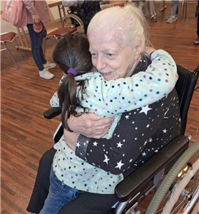 eine Seniorin und ein Kind umarmen sich herzlich