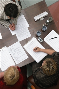 Bild von oben zeigt drei Frauen und Besprechungsunterlagen auf dem Tisch