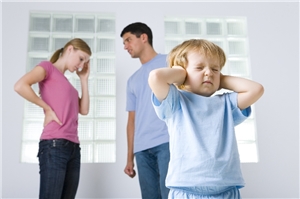 Im Hintergrund streiten zwei junge Eltern, Kind hält sich die Ohren zu.