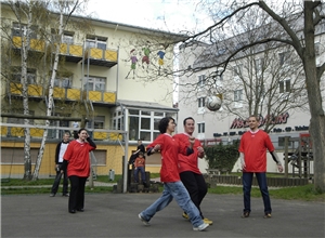 Mehrere Jugendliche spielen in einem Hof Fußball.