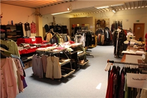 Einkaufscenter mit mehreren vollen Kleiderständern.