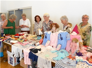 Die katholische Frauengemeinschaft St. Maria zeigt stolz ihre Spenden für die Babykleiderkammer. Vieles ist selbstgemacht. 
