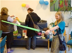 Ein Mädchen hat ein Spielzeug-Lichtschwert entdeckt und probiert es aus. Tauschparty 2016_2