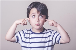 Ein Junge hält sich mit beiden Händen die Ohren zu.