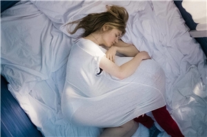 Filmszene: Die schwangere Mutter liegt im Bett. Filmszene: Die schwangere Mutter liegt im Bett.