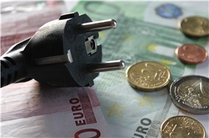 Ein Stecker liegt auf Geldscheinen und Münzen - das Foto symbolisiert den Zusammenhang zwischen Stromverbrauch und Kosten. Ein Stecker liegt auf Geldscheinen und Münzen - das Foto symbolisiert den Zusammenhang zwischen Stromverbrauch und Kosten.