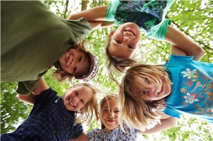 Kinder bilden einen Kreis und schauen nach unten. Kinder