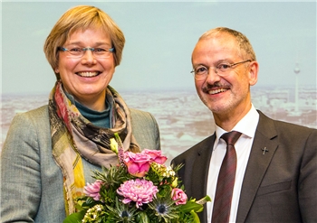 Mann gratuliert Frau mit Blumenstrauß