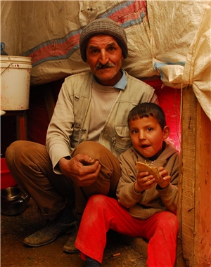Ein älterer Mann und ein kleiner Junge in einem Zelt.