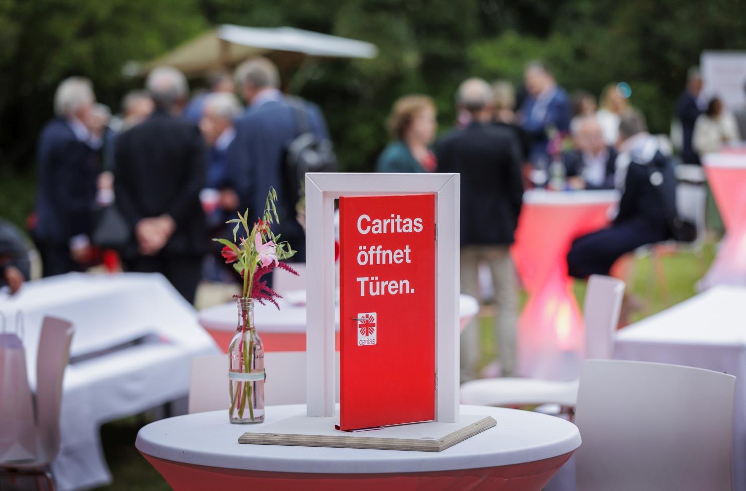 Kleine rote Tür mit der Aufschrift Caritas öffnet Türen