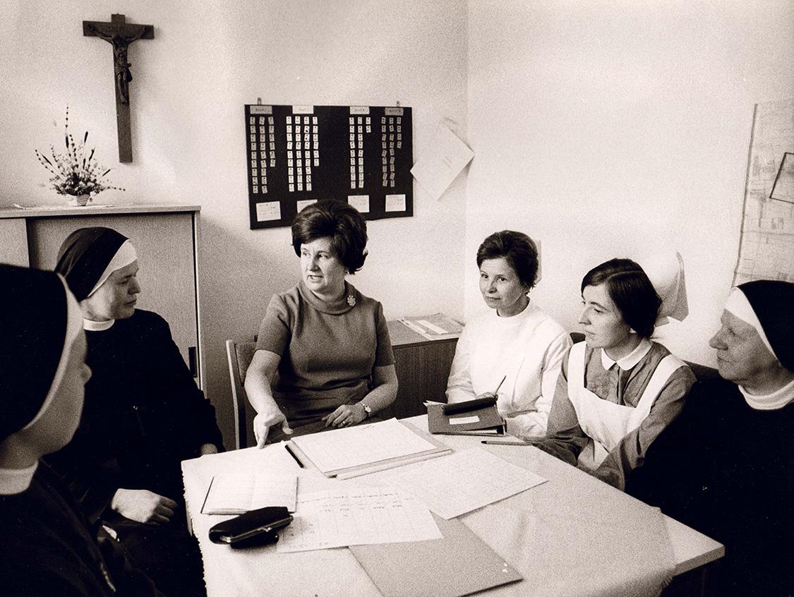 An einem Tisch sitzen sechs Frauen. Sie besprechen den weiteren Dienst in der Sozialstation Mainz. 