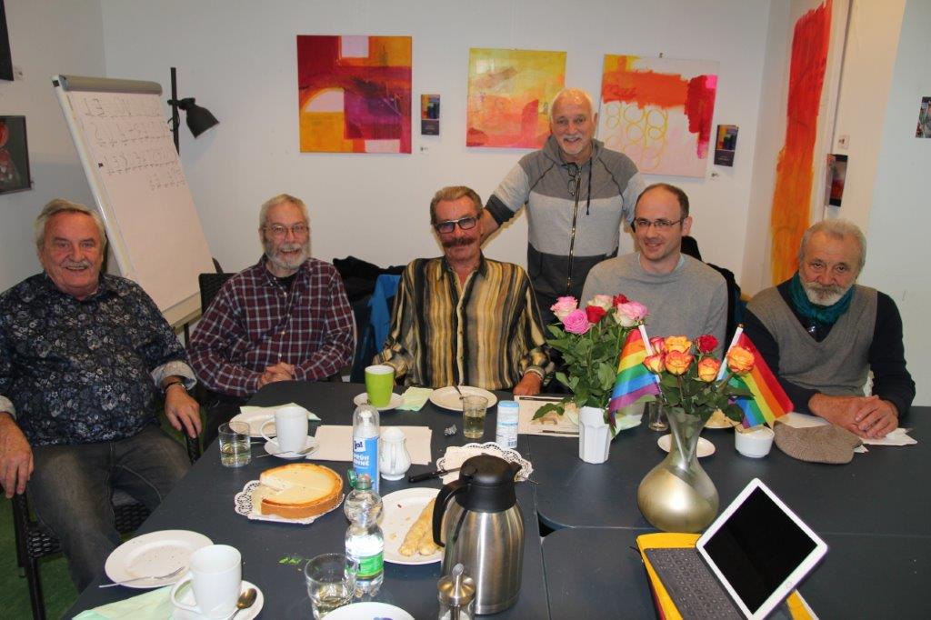 Sechs ältere Herren beim Kaffeetrinken an einem Tisch.