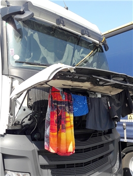 Wäsche hängt zum Trocknen an Motorhaube von LKW.